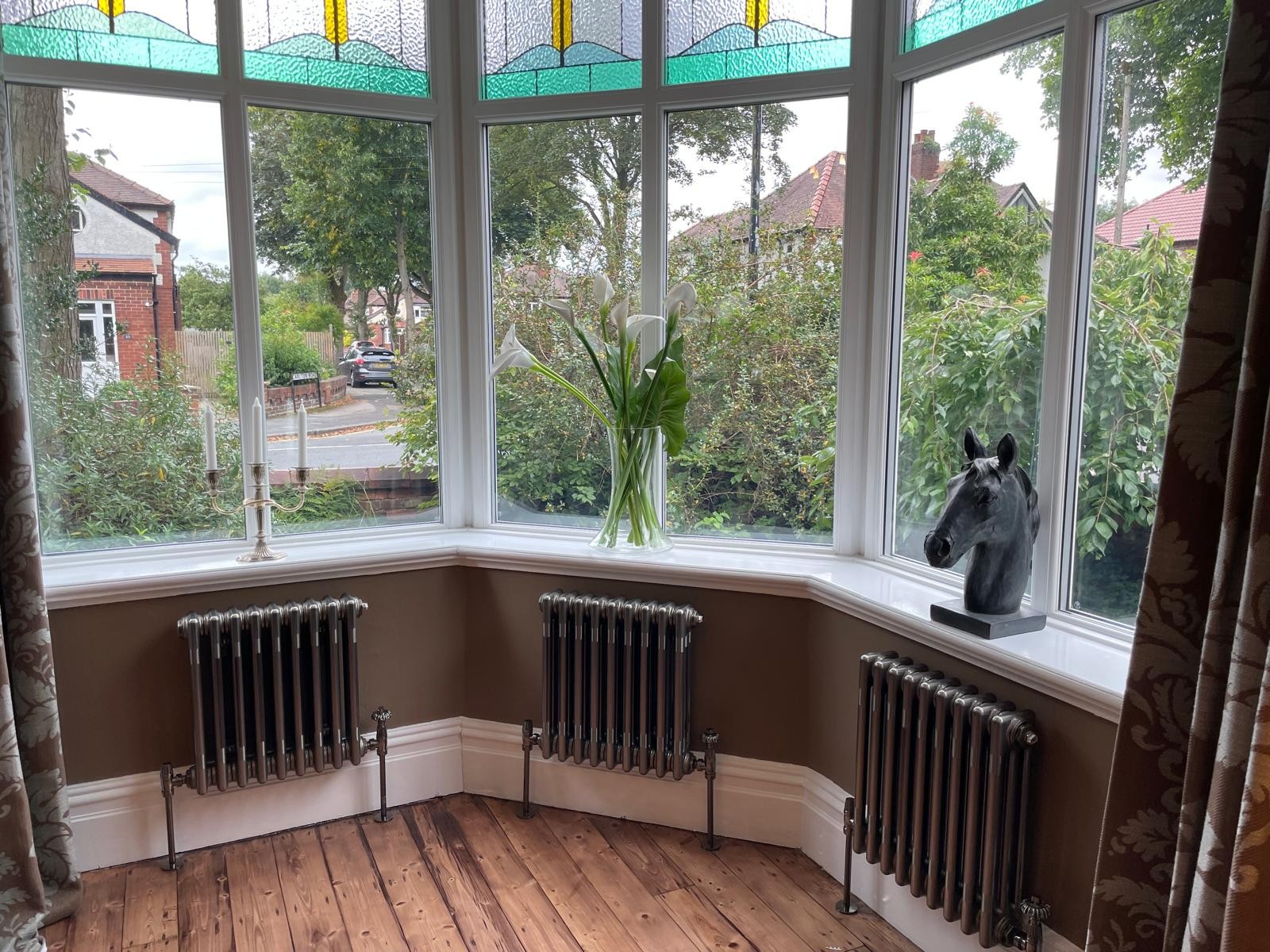 Restored cast iron radiators installed under a bay window in a Manchester period property