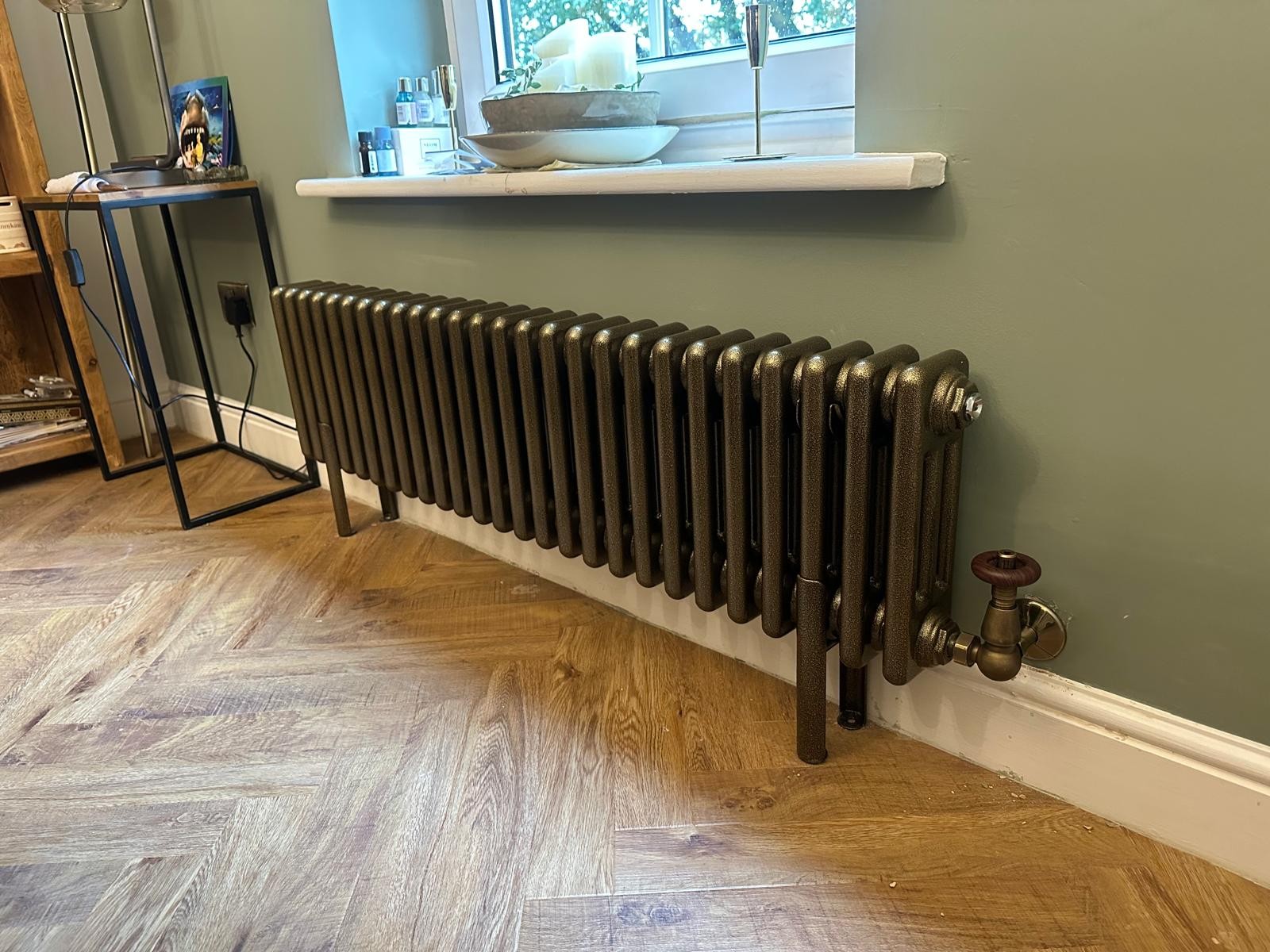 Textured bronze cast iron radiator installed on a parquet floor in a period Manchester house
